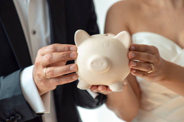 Bride and groom holding piggy bank.